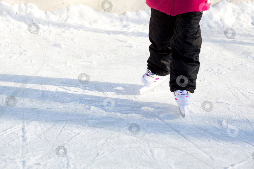 Скачать Детские пластиковые раздвижные коньки с регулировкой размера крупным планом на льду зимой на открытом воздухе. Катание на роликах в морозный солнечный день, активные зимние виды спорта и образ жизни фотосток Ozero