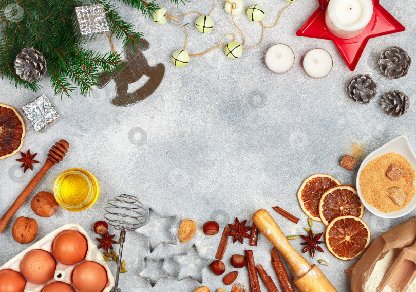 Скачать Рождественский фон для выпечки с ингредиентами (мука, яйца, сахар, мед, орехи, специи, цитрусовые цукаты) для приготовления домашних пряников на фоне светлого бетона. пространство для копирования фотосток Ozero