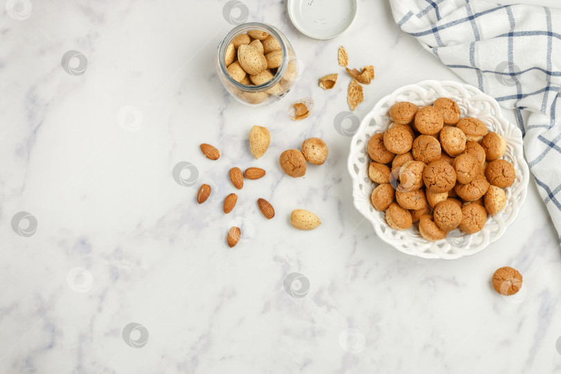 Скачать Амаретти - традиционное итальянское миндальное печенье в белой тарелке на мраморном фоне с видом сверху. Печенье "Амареттини". Выборочный фокус, пространство для копирования фотосток Ozero