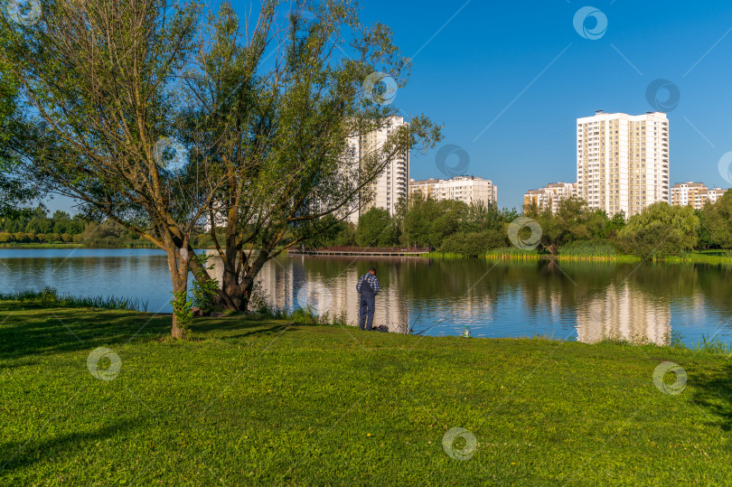 Скачать Рыбак на пруду ловит рыбу фотосток Ozero