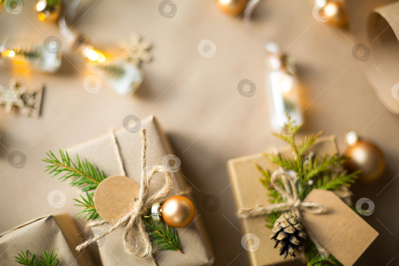 Скачать Упакуйте подарок на Рождество и новый год из экологически чистых материалов: крафт-бумаги, живых еловых веток, шишек, шпагата. Бирки с макетом, натуральный декор, ручная работа, сделай сам. Праздничное настроение. Рождественский фон фотосток Ozero