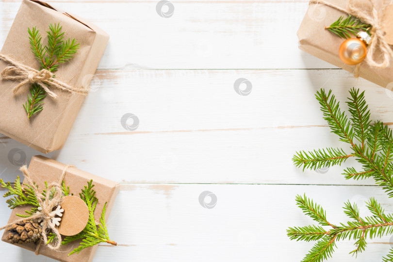 Скачать Подарочная коробка на Рождество и новый год из экологически чистых материалов: крафт-бумаги, живых еловых веток, шишек, шпагата. Бирки с макетом, натуральный декор, ручная работа, сделай сам. Плоско, фон, рамка, минимализм фотосток Ozero