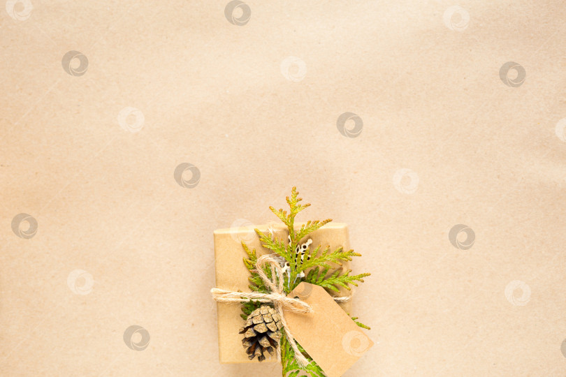 Скачать Подарочная коробка на Рождество и новый год из экологически чистых материалов: крафт-бумага, живые еловые ветки, шишки, шпагат. Бирки с макетом, натуральный декор, ручная работа, сделай сам. Плоско, фон, рамка, Минимализм фотосток Ozero