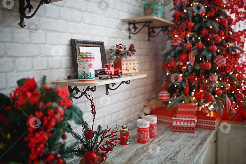 Скачать Подарки в коробках крупным планом под рождественской елкой с красно-белым декором в белой гостиной. Новый год, европейский стиль, декор кухни. Место для текста, выборочный фокус на автомобиле фотосток Ozero