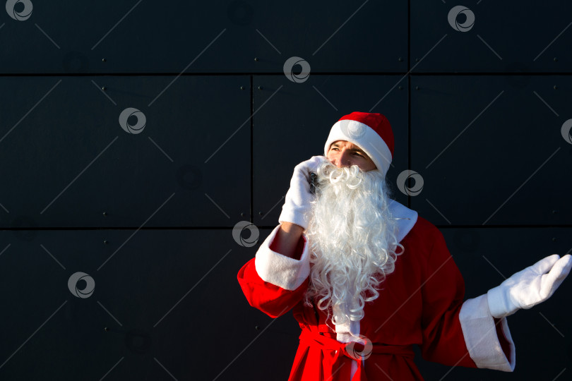 Скачать Современный Санта-Клаус разговаривает по телефону. Заказ услуг аниматора на Рождество и новый год. Онлайн-поздравления через Интернет и мобильную связь, социальная дистанция фотосток Ozero