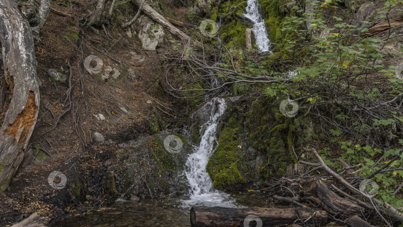 Скачать Живописный водопад стекает по склону горы. фотосток Ozero