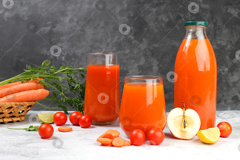 Скачать Детокс-напиток в стеклянной банке и стакане, ломтики моркови, яблок и помидоров на темном фоне. Свежий натуральный морковно-яблочный смузи или сок, концепция похудения, свежие фрукты и овощи, избирательный подход фотосток Ozero