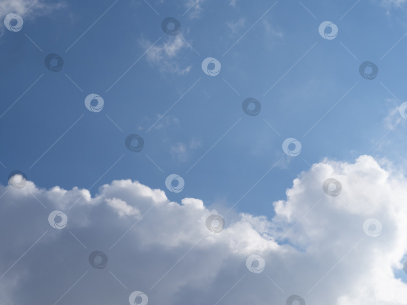 Скачать Белые облака, освещенные солнцем, на фоне голубого неба фотосток Ozero