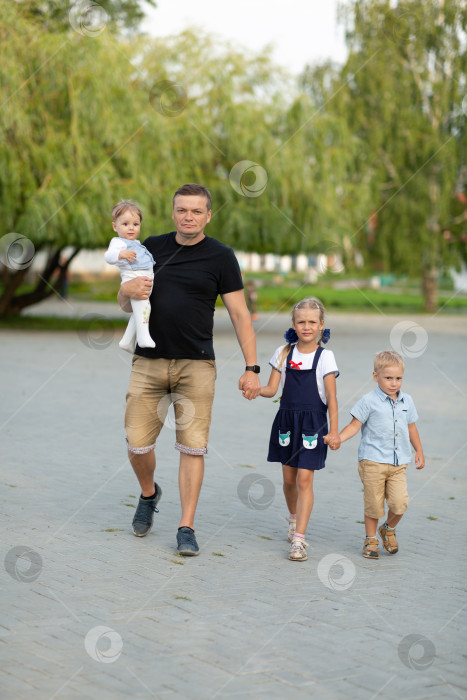 Скачать Папа с тремя маленькими детьми в парке, концепция Дня отца фотосток Ozero