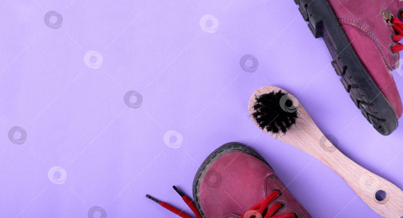 Скачать Щетка для обуви с деревянной ручкой и натуральной щетиной для чистки обуви и сапог из нубука на фиолетовом фоне. Аксессуар для ухода за обувью. фотосток Ozero