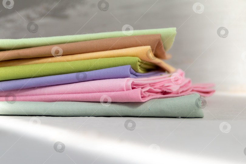 Скачать Стопка разноцветной хлопчатобумажной ткани на сером фоне фотосток Ozero