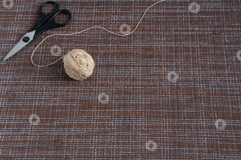 Скачать A ball with thick threads and scissors on the table. фотосток Ozero