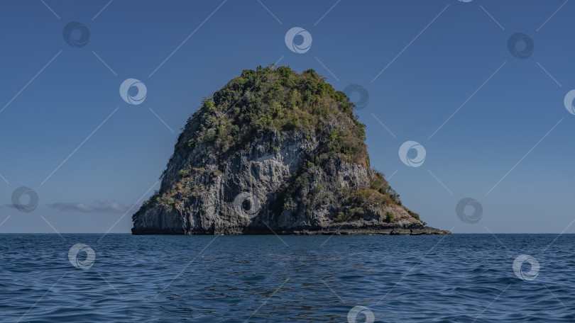 Скачать Одинокий остров возвышается в голубом океане. фотосток Ozero