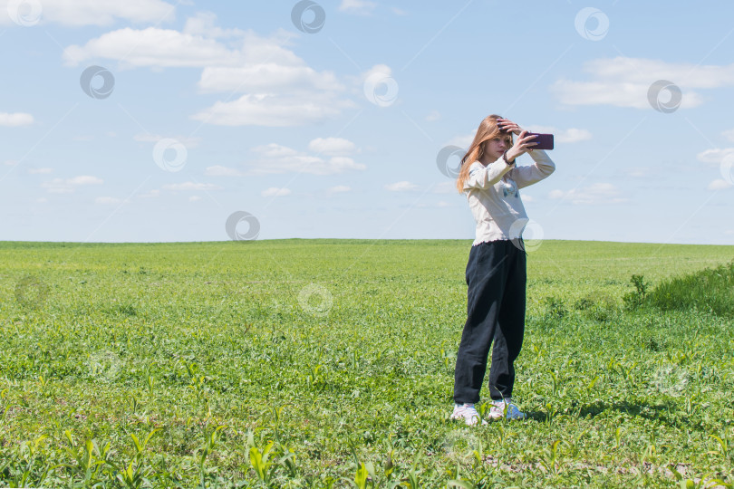 Скачать Молодая девушка фотографирует себя в поле фотосток Ozero
