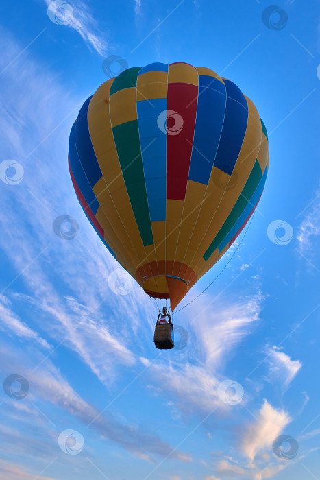 Скачать Разноцветный воздушный шар летит в голубом облачном небе фотосток Ozero