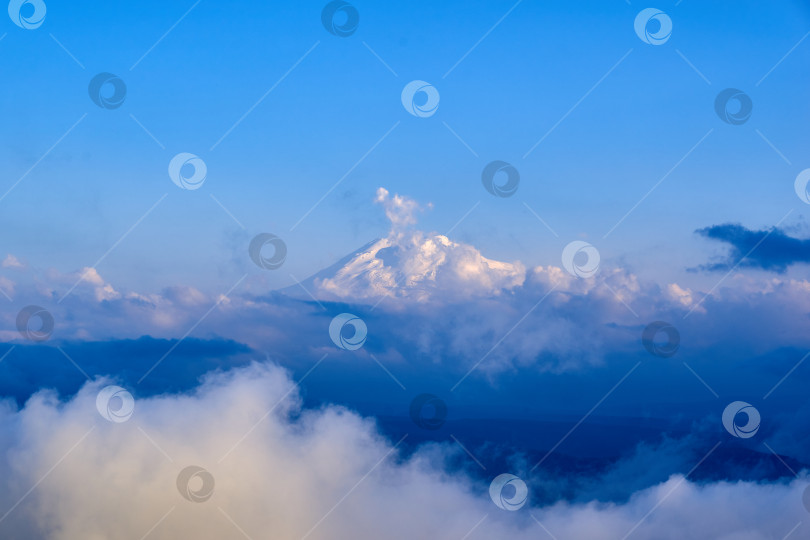 Скачать Вид на Эльбрус сквозь облака с плато Бермамыт. фотосток Ozero