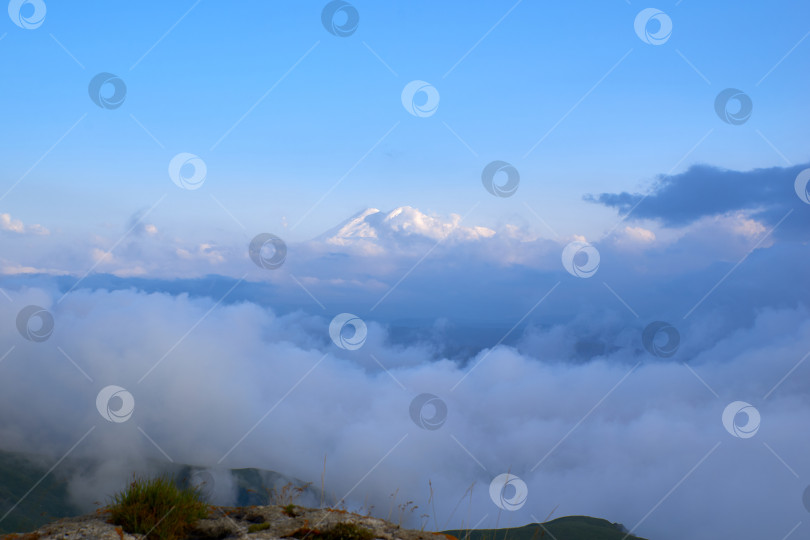 Скачать Вид на Эльбрус сквозь облака с плато Бермамыт. фотосток Ozero