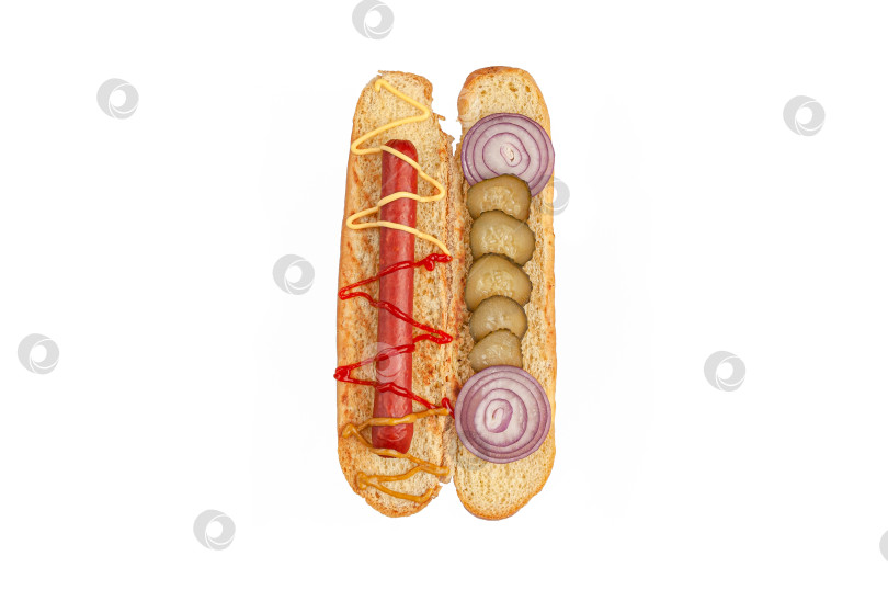 Скачать Ингредиенты для хот-догов. Нарезанная булочка содержит ингредиенты: колбасу, соус, маринованные огурцы и лук. Вид сверху. Белый фон. Изолированный. фотосток Ozero
