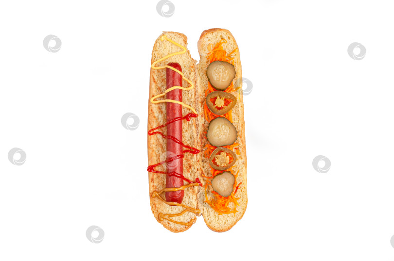 Скачать Ингредиенты для хот-догов. Нарезанная булочка содержит ингредиенты: колбасу, соус, маринованную морковь и перец халопно. Вид сверху. Белый фон. Изолированный. фотосток Ozero