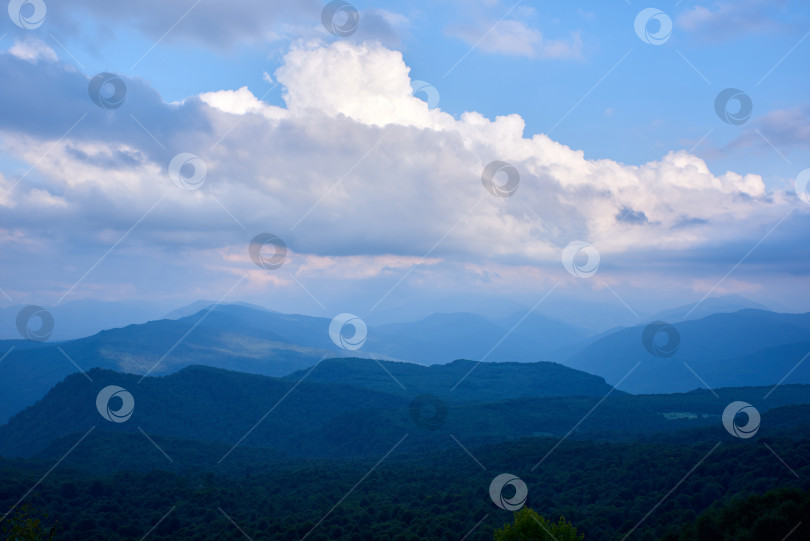 Скачать Речевые облака в лучах солнца над лесистыми горами фотосток Ozero