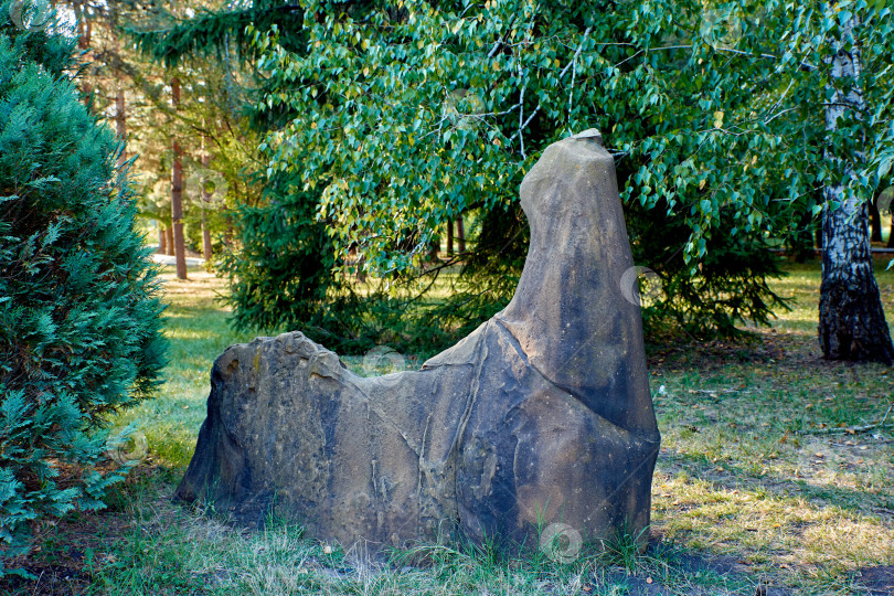 Скачать Камень, похожий на лошадь, на зеленой траве, на фоне деревьев. Необычный камень. фотосток Ozero