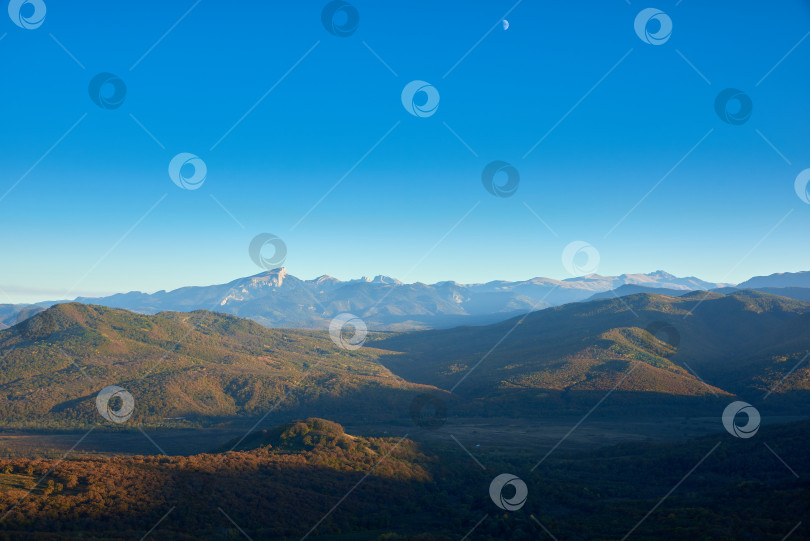 Скачать Горная долина с осенним лесом на закате. Голубое небо и луна. фотосток Ozero