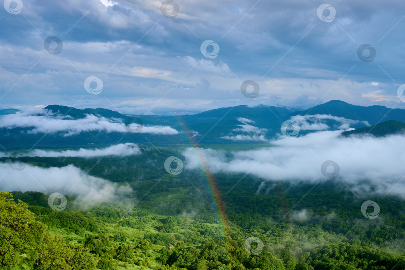 Скачать Радуга на фоне кучевых облаков и гор фотосток Ozero