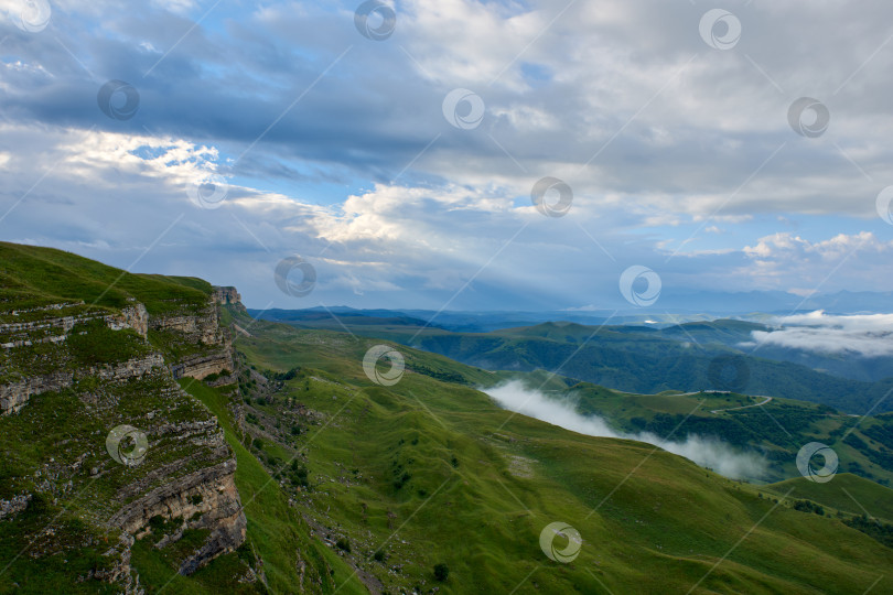 Скачать Туман над зеленой горной долиной под красивыми кучевыми облаками на рассвете фотосток Ozero