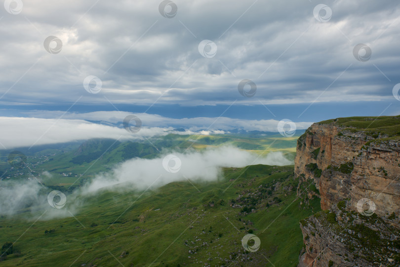 Скачать Туман над зеленой горной долиной под красивыми кучевыми облаками на рассвете фотосток Ozero