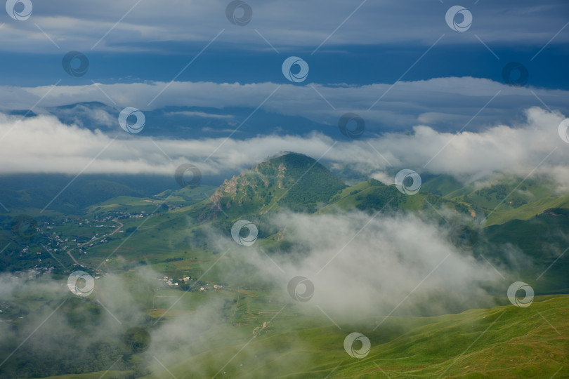 Скачать Туман над солнечной зеленой горной долиной с маленькой деревушкой фотосток Ozero