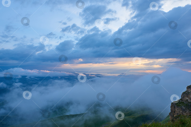 Скачать Закат освещает облака над горной зеленой долиной в тумане фотосток Ozero