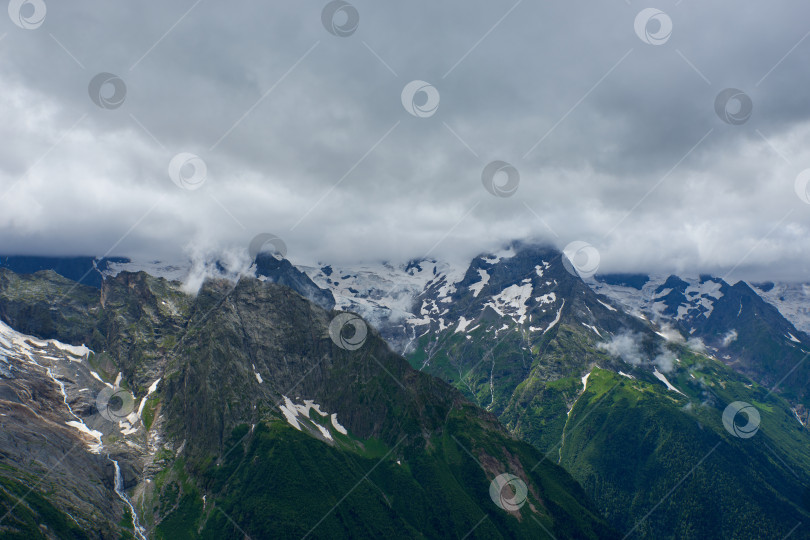 Скачать Ледник и ручей на горном хребте в облаках и тумане. Домбай, Карачаево-Черкесия, Россия фотосток Ozero