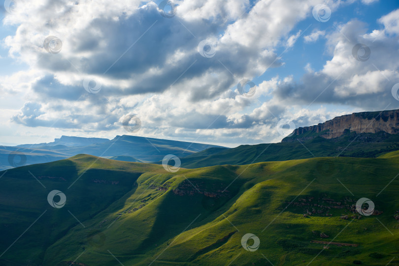 Скачать Зеленая долина и скалистый хребет под облачным небом. Карачаево-Черкесия, Северный Кавказ, Россия фотосток Ozero