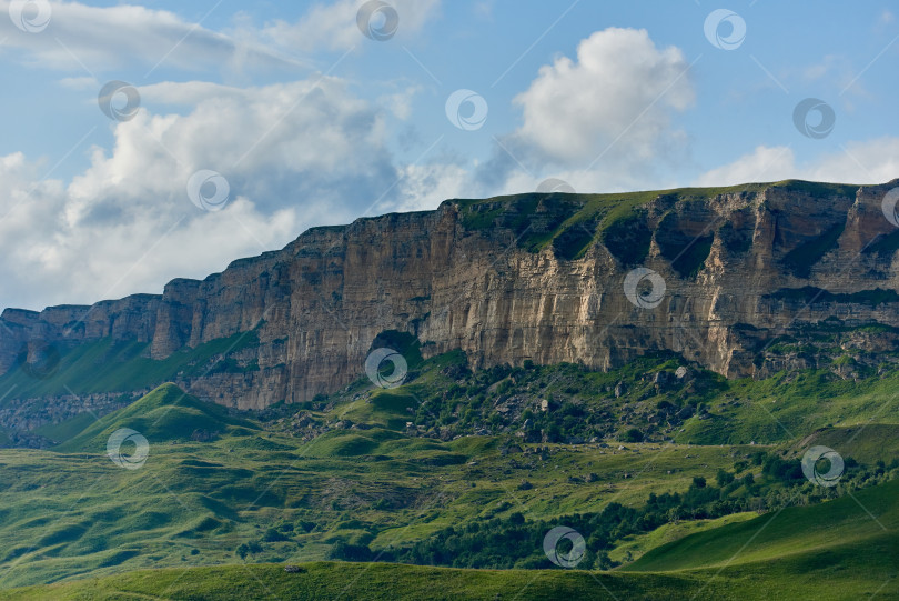 Скачать Зеленая долина и скалистый хребет под облачным небом. Карачаево-Черкесия, Северный Кавказ, Россия фотосток Ozero