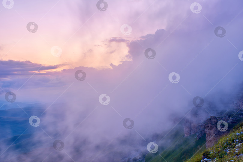 Скачать Закат в горах. Солнце светит сквозь туман над горным хребтом. Карачаево-Черкесия, Северный Кавказ, Россия фотосток Ozero