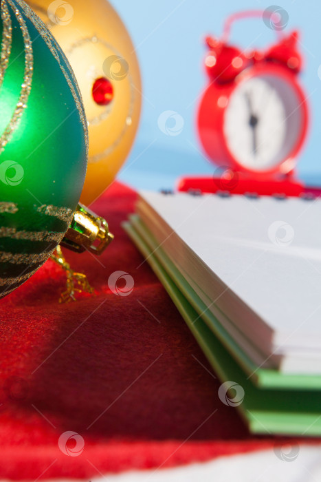 Скачать Мини-будильник со шляпой Санты и рождественскими украшениями на синем фоне с пространством для текста фотосток Ozero