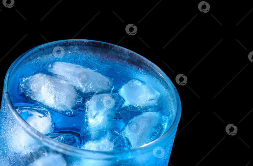 Скачать бокал со льдом и синим коктейлем на черном фотосток Ozero