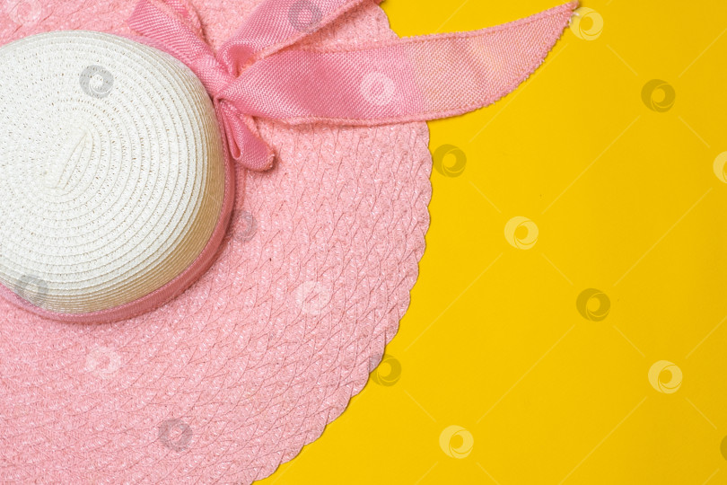 Скачать розовая летняя женская шляпка лежит на желтом фоне фотосток Ozero