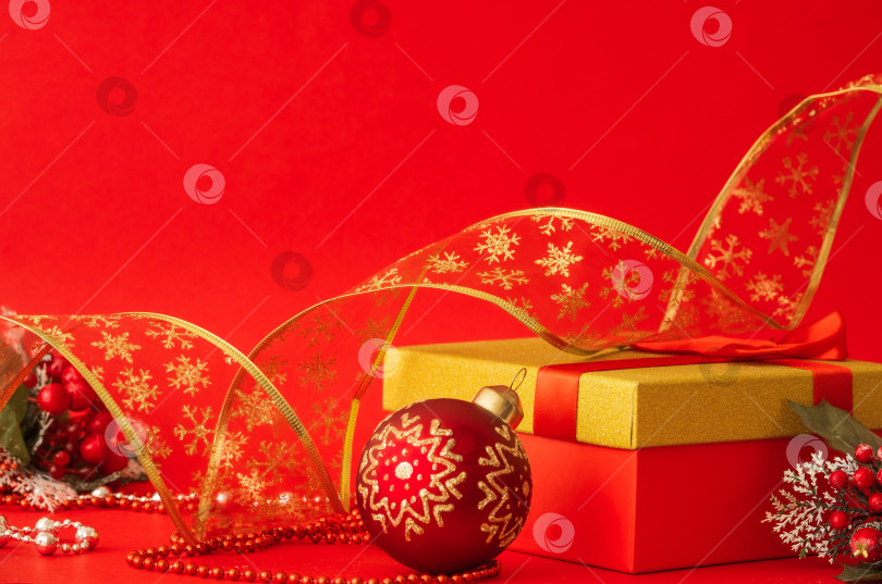 Скачать коробка с подарком и рождественским шаром на красном фотосток Ozero