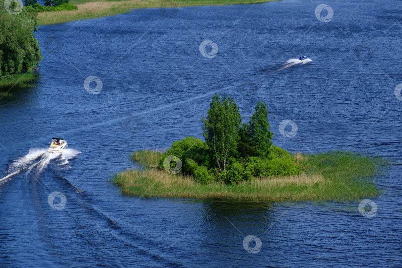 Скачать лодка, плывущая по голубой воде рядом с зеленым островом фотосток Ozero