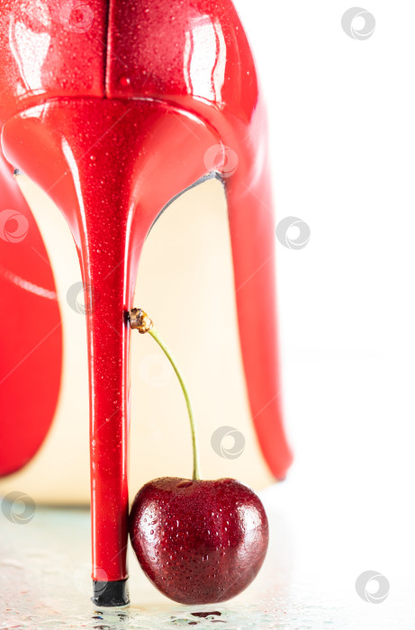 Скачать мокрые от капель воды женские блестящие красные туфли на шпильке и вишневая ягода на белом фоне фотосток Ozero