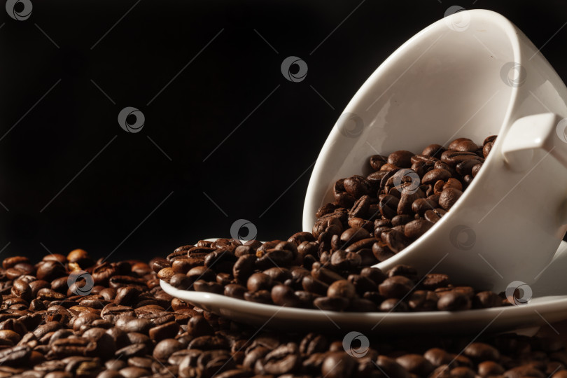 Скачать белая чашка и обжаренные кофейные зерна на столе фотосток Ozero