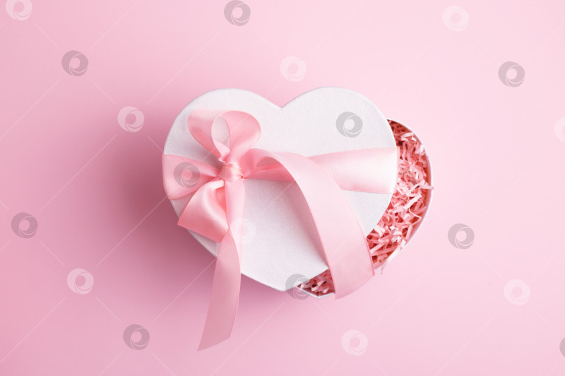 Скачать Праздничная коробка в форме сердца, украшенная розовым бантиком. фотосток Ozero