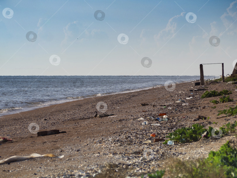 Скачать Морской пляж усеян пластиковыми бутылками и другим мусором. Концепция защиты планеты Земля. фотосток Ozero