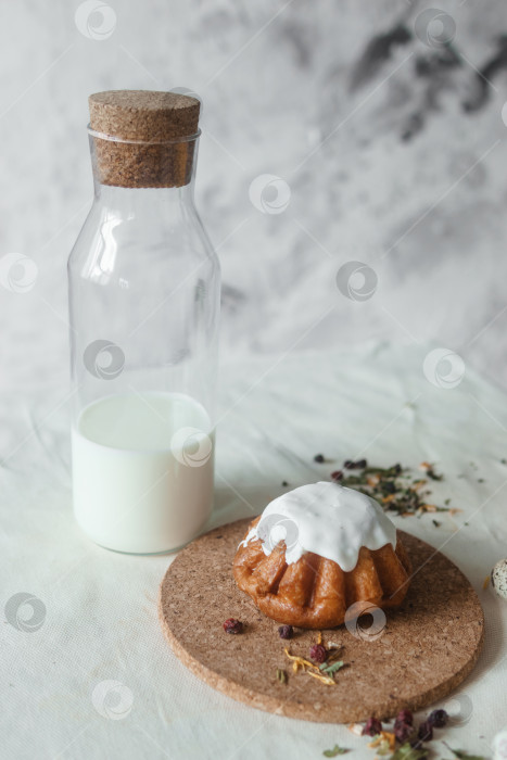 Скачать Пасхальный кулич и бутылка коровьего молока на белом столе крупным планом. Концепция празднования Счастливой Пасхи фотосток Ozero