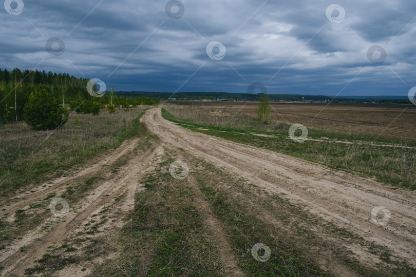 Скачать проселочная дорога, уходящая вдаль на фоне облачного неба фотосток Ozero