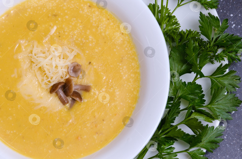 Скачать желтый тыквенный суп с грибами в тарелке на столе фотосток Ozero
