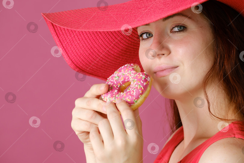 Скачать женщина с длинными волосами в большой красной шляпе и сладким пончиком в руке фотосток Ozero