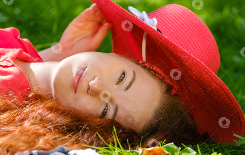 Скачать молодая женщина в красной шляпе лежит в парке летним днем фотосток Ozero