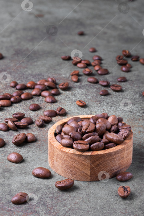 Скачать Обжаренные кофейные зерна в деревянной миске и на поверхности вокруг фотосток Ozero